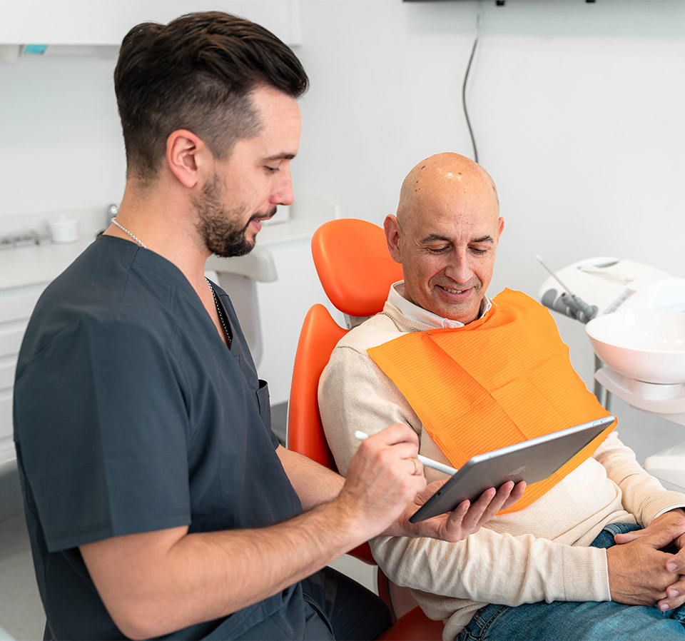 Odontologo Jose Manuel Cervera en su consultorio de Laganes Explicando a un Paciente